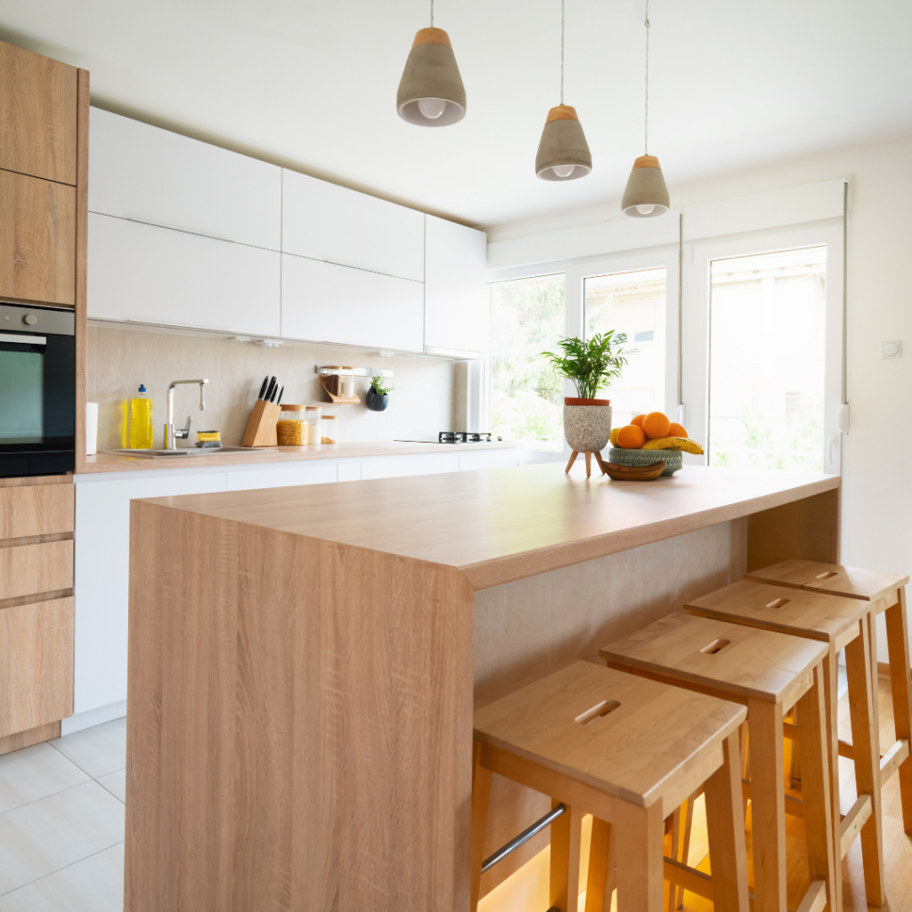Modern white and wood kitchen cabinets in a bright Myrtle Beach home featuring a sleek waterfall island.