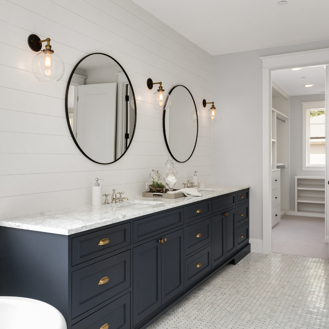Custom navy blue bathroom cabinets with gold hardware and a white marble countertop installed in a Myrtle Beach home.